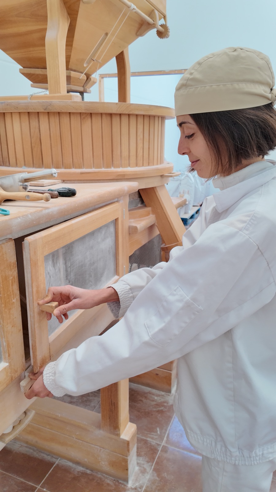 Almudena ajustando el cernedor del molino de piedra