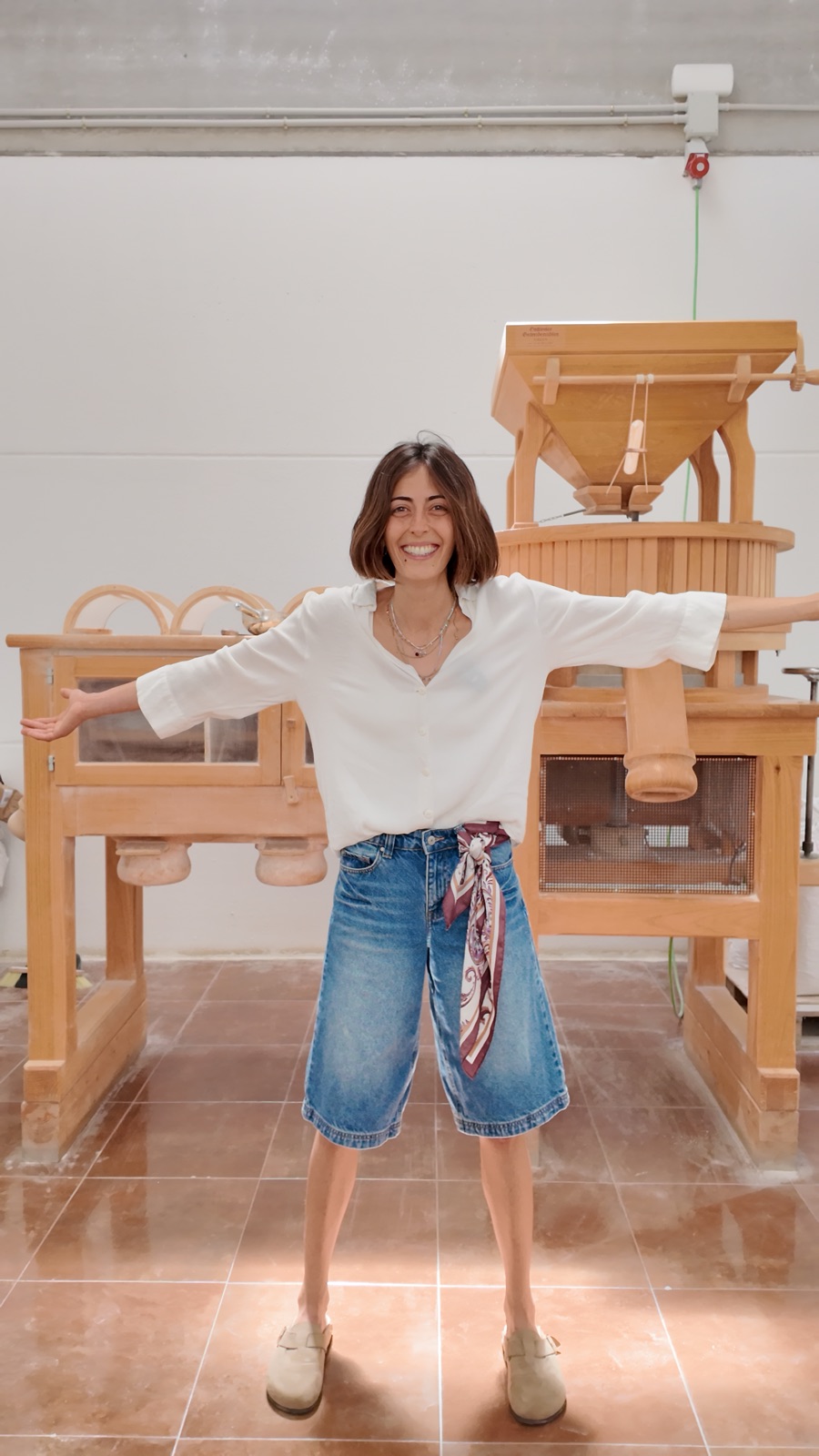 Almudena sonriendo junto al molino de piedra