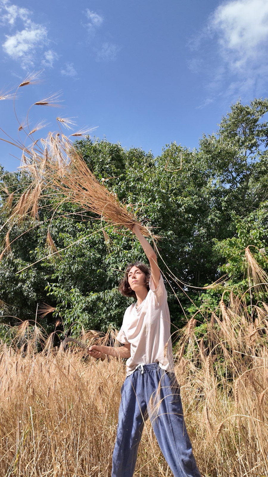 Almudena sosteniendo espigas de trigo en el campo